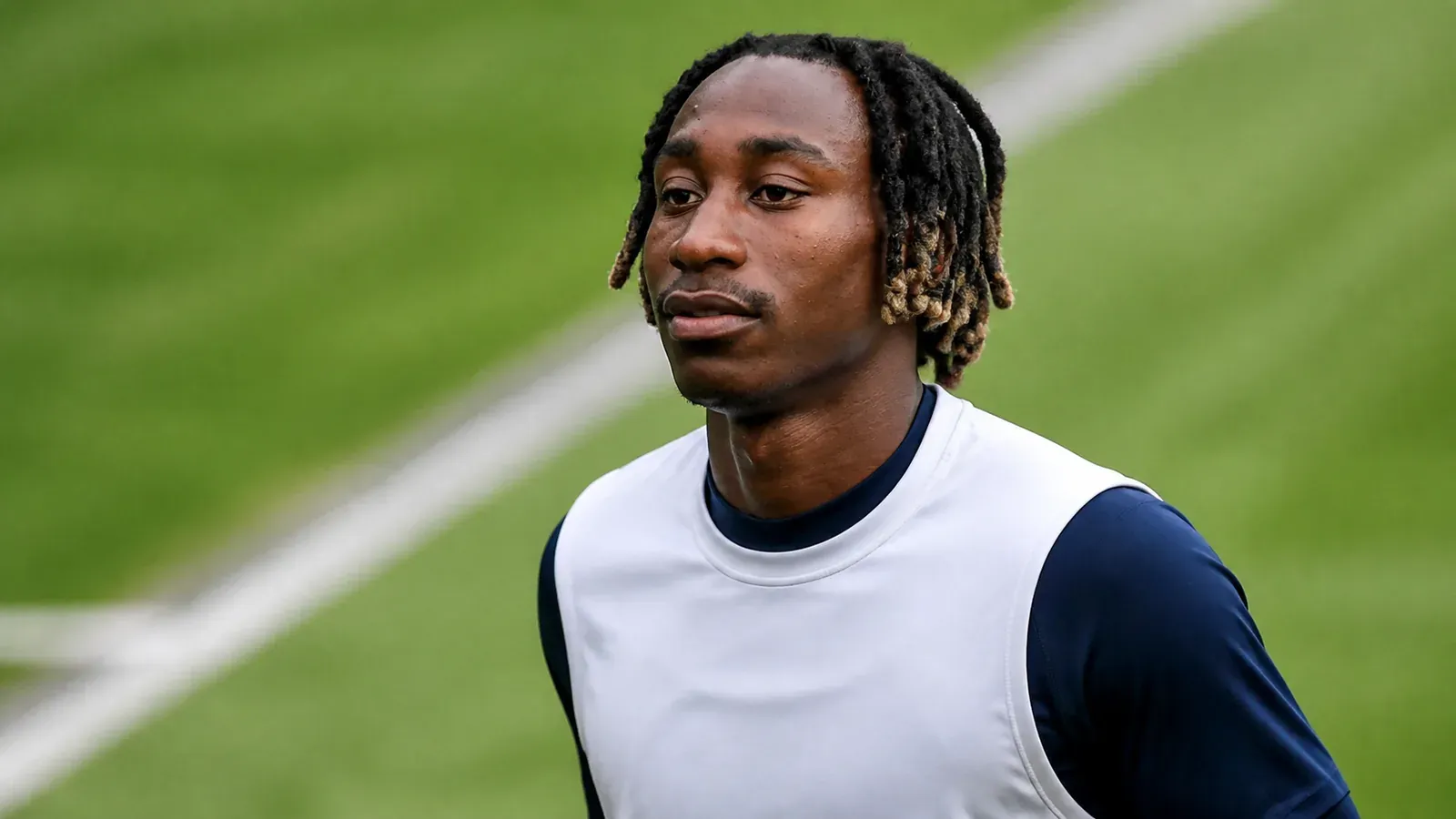 Yan Diomande realiza un calentamiento sobre un campo de fútbol.